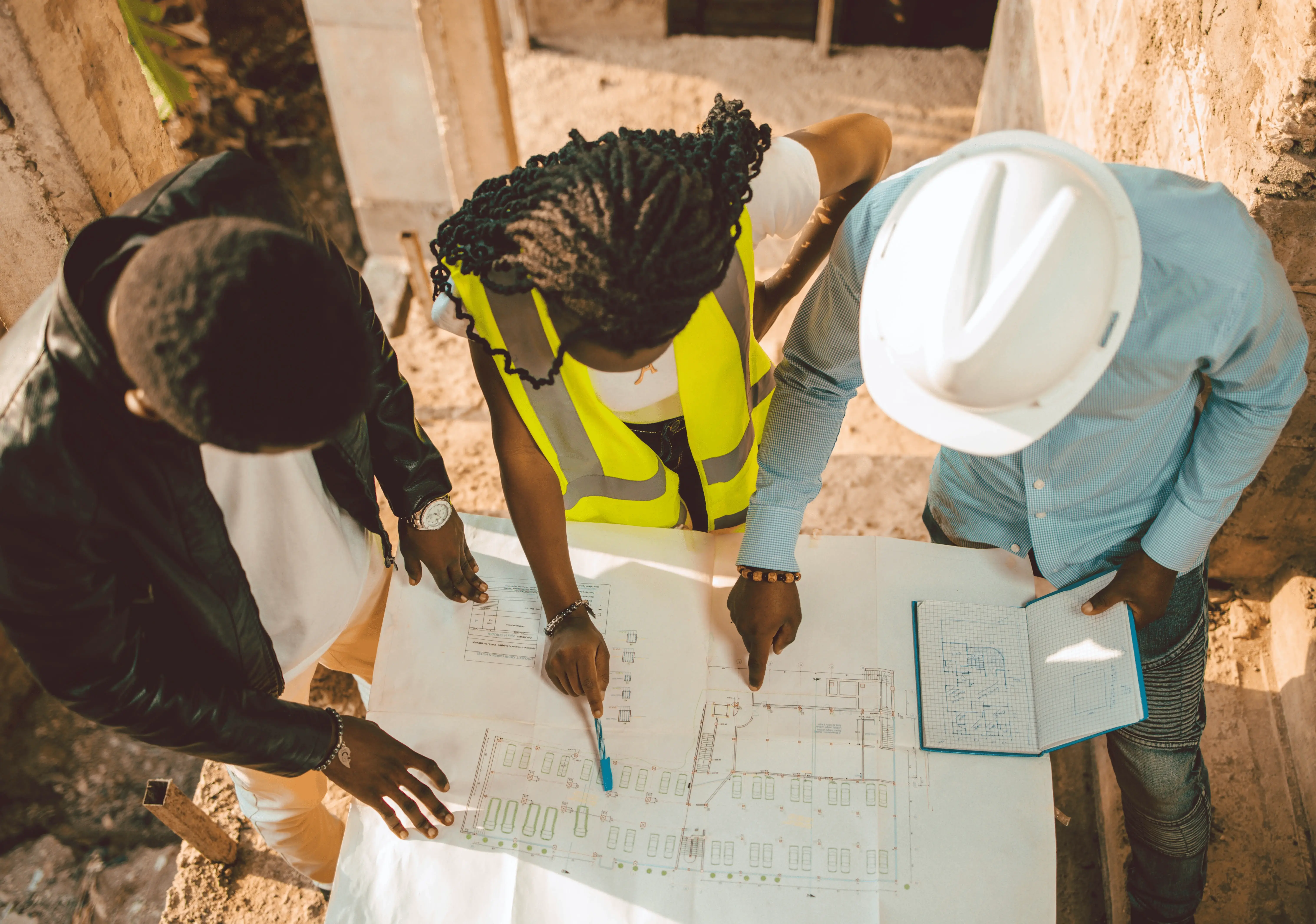A diverse team of engineers and contractors reviewing blueprints on a construction site